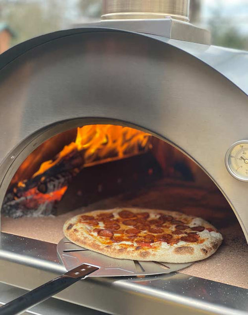 cooking pizza with Cru Champion Bundle wood fired oven